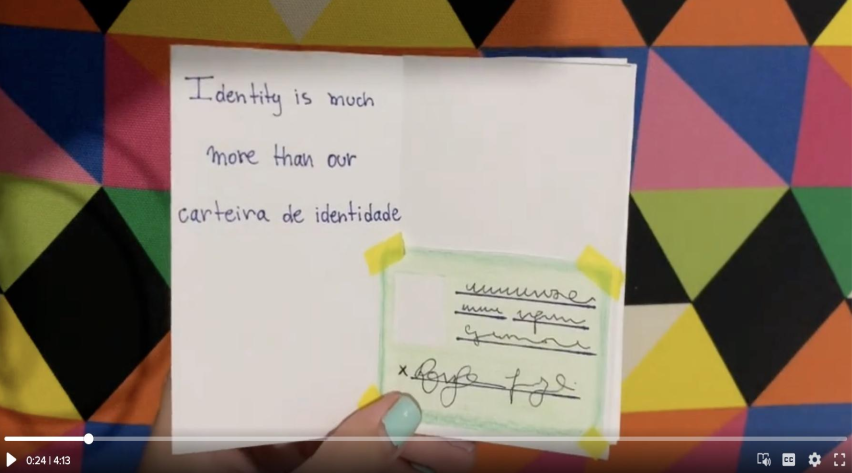 This photo shows one page of Juliana's zine. On the left zine page she has written, 'Identity is much more than our carteira de identidade.' On the right zine page, she has drawn an identity card with lines and scribbles to represent her identifying information and signature.